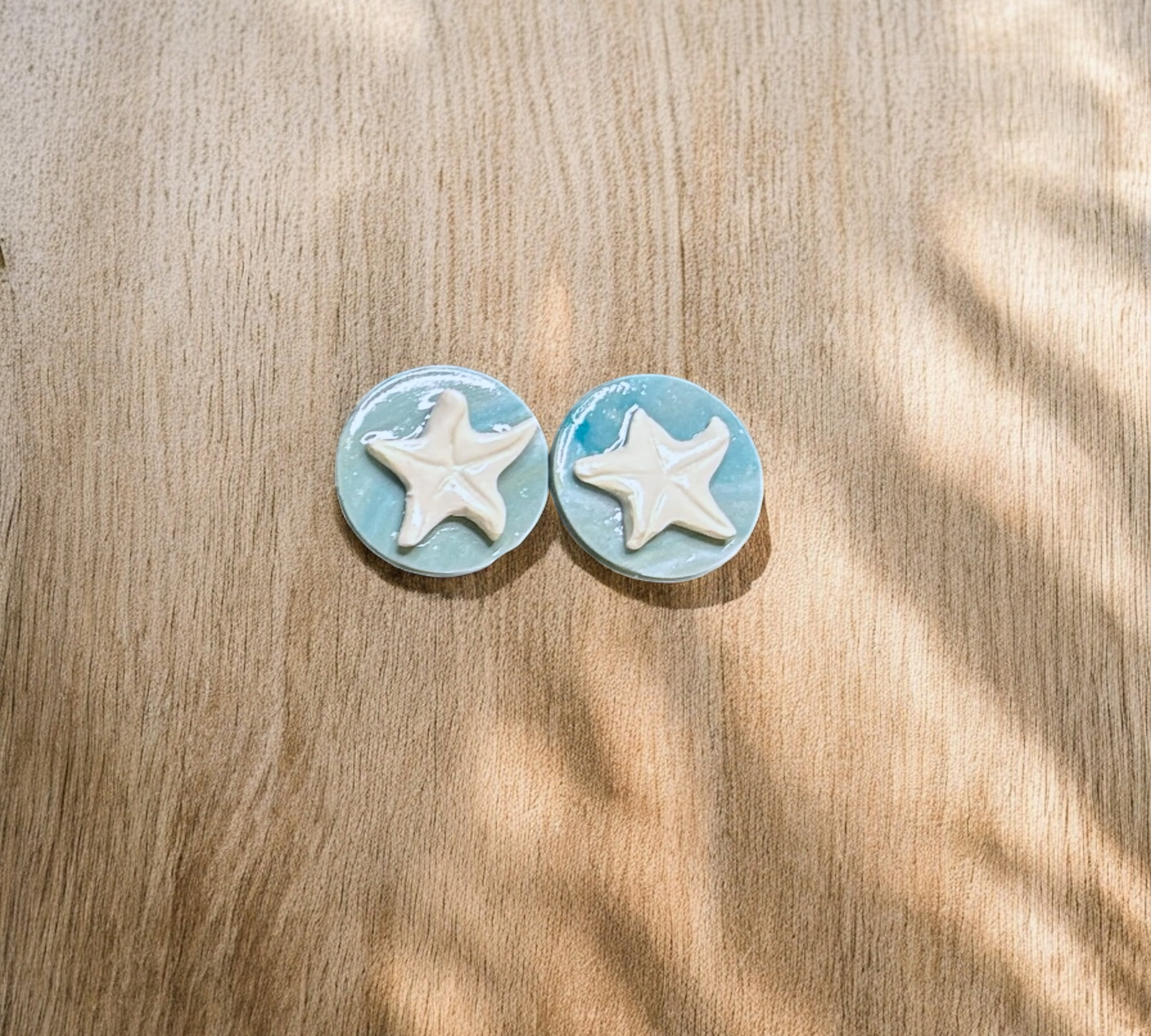 Starfish-shaped earrings on a wooden surface