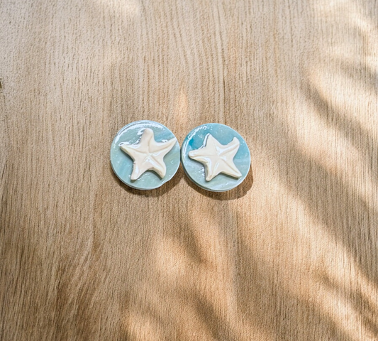 Starfish-shaped earrings on a wooden surface