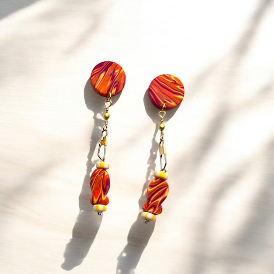 Pair of colorful goldfish earrings on a light background